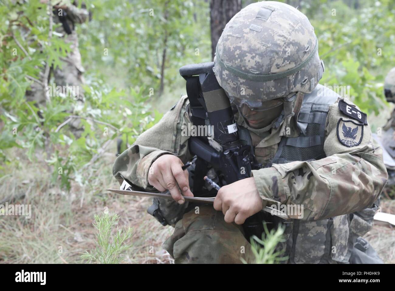 U.S. Army Reserve Spc. Nicolas Cholula, a combat documentation production specialist from Oxnard, California, with the 311th Signal Command (Theater Support Unit), plots his points to the first rally point during Land Navigation event at the 2018 U.S. Army Reserve Best Warrior Competition at Fort Bragg, North Carolina, June 14, 2018. Today, U.S. Army Reserve Soldiers give everything they have to push past their limits and finish the last day of events in the 2018 U.S. Army Reserve Best Warrior Competition. Stock Photo
