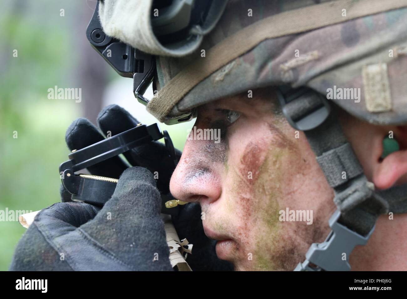 U.S. Army Reserve Sgt. Thomas Crump, a chemical, biological, radiological, nuclear noncommissioned officer from Rock Spring, Georgia, with the 327th Chemical Company, 415th Chemical Brigade, 76th Operational Response Command, looks through a lensatic compass at the 2018 U.S. Army Reserve Best Warrior Competition at Fort Bragg, North Carolina, June 14, 2018. When all scores have been calculated and competitors have rested after the grueling competition, the German Armed Forces Proficiency Badge, Excellence in Competition pistol badge and the U.S. Army Reserve 2018 Best Warrior noncommissioned o Stock Photo