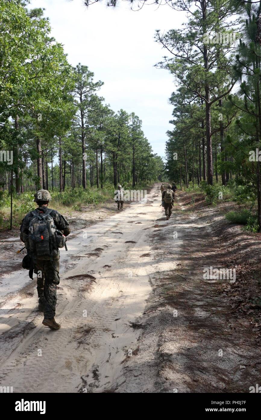 U.S. Army Reserve Soldiers move through a training area during the 2018 U.S. Army Reserve Best Warrior Competition at Fort Bragg, North Carolina, June 14, 2018. When all scores have been calculated and competitors have rested after the grueling competition, the German Armed Forces Proficiency Badge, Excellence in Competition pistol badge and the U.S. Army Reserve 2018 Best Warrior noncommissioned officer and enlisted Soldier titles are awarded. Stock Photo