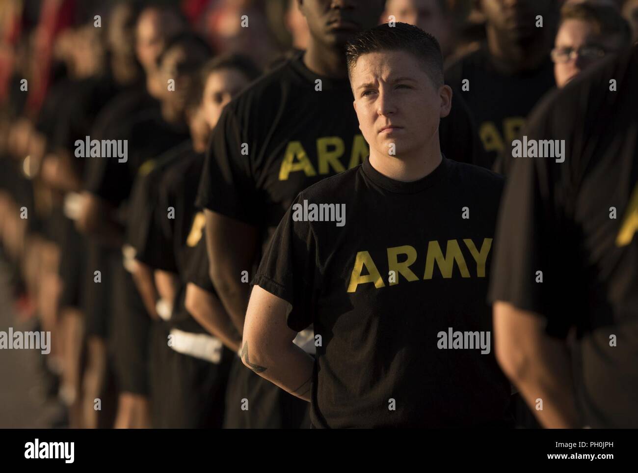 U.S. Army Soldiers stand listening to the opening remarks during the Army 243rd Birthday Run Celebration at Joint Base Langley-Eustis, Virginia, June 14, 2018. During the event, attendees celebrated the Army’s heritage with a cake cutting ceremony and 3.1. mile run. Stock Photo