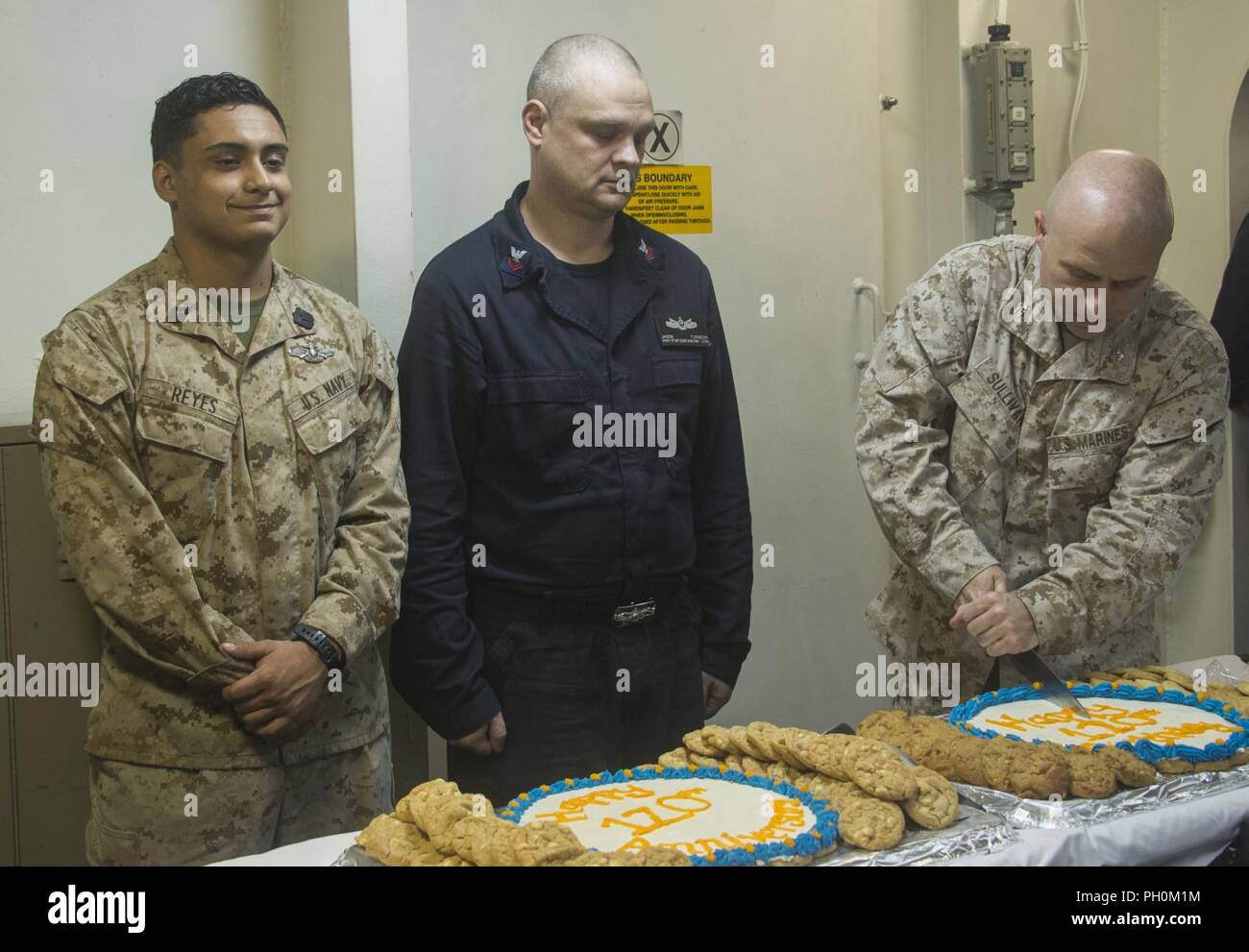U.S. 5TH FLEET AREA OF OPERATIONS (June 17, 2018) U.S. Marine Corps Col. Farrell J. Sullivan, commanding officer of the 26th Marine Expeditionary Unit (MEU) cuts a cake in celebration of the 120th Hospital Corpsman birthday in medical triage aboard the Wasp-class amphibious assault ship USS Iwo Jima (LHD 7) during the celebration, June 17, 2018. Iwo Jima, homeported in Mayport, Fla., is on deployment to the U.S. 5th Fleet area of operations in support of maritime security operations to reassure allies and partners, and preserve the freedom of navigation and the free flow of commerce in the reg Stock Photo
