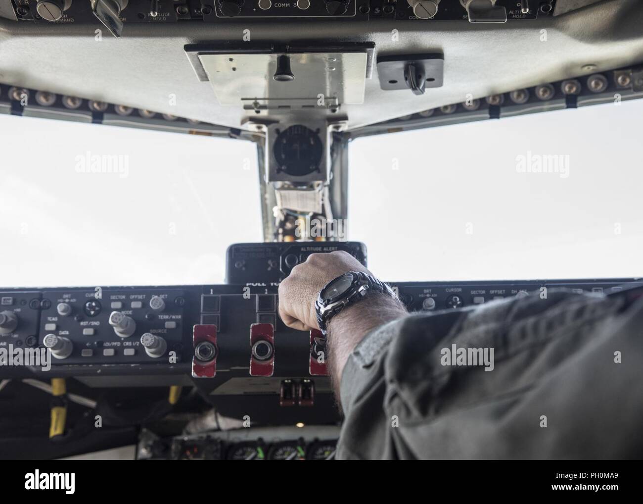 A U.S. Air National Guard pilot from the 121st Air Refueling Wing, Ohio adjusts the controls in the cockpit of a KC-135 Stratotanker after takeoff from Rickenbacker Air National Guard Base, Ohio June 15, 2018.  The Stratotanker was en route to do a refueling exercise over the Atlantic Ocean. Stock Photo