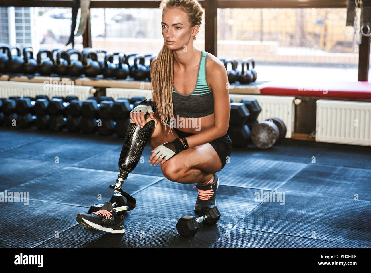 Portrait of fitness disabled woman in tracksuit doing crossfit ...