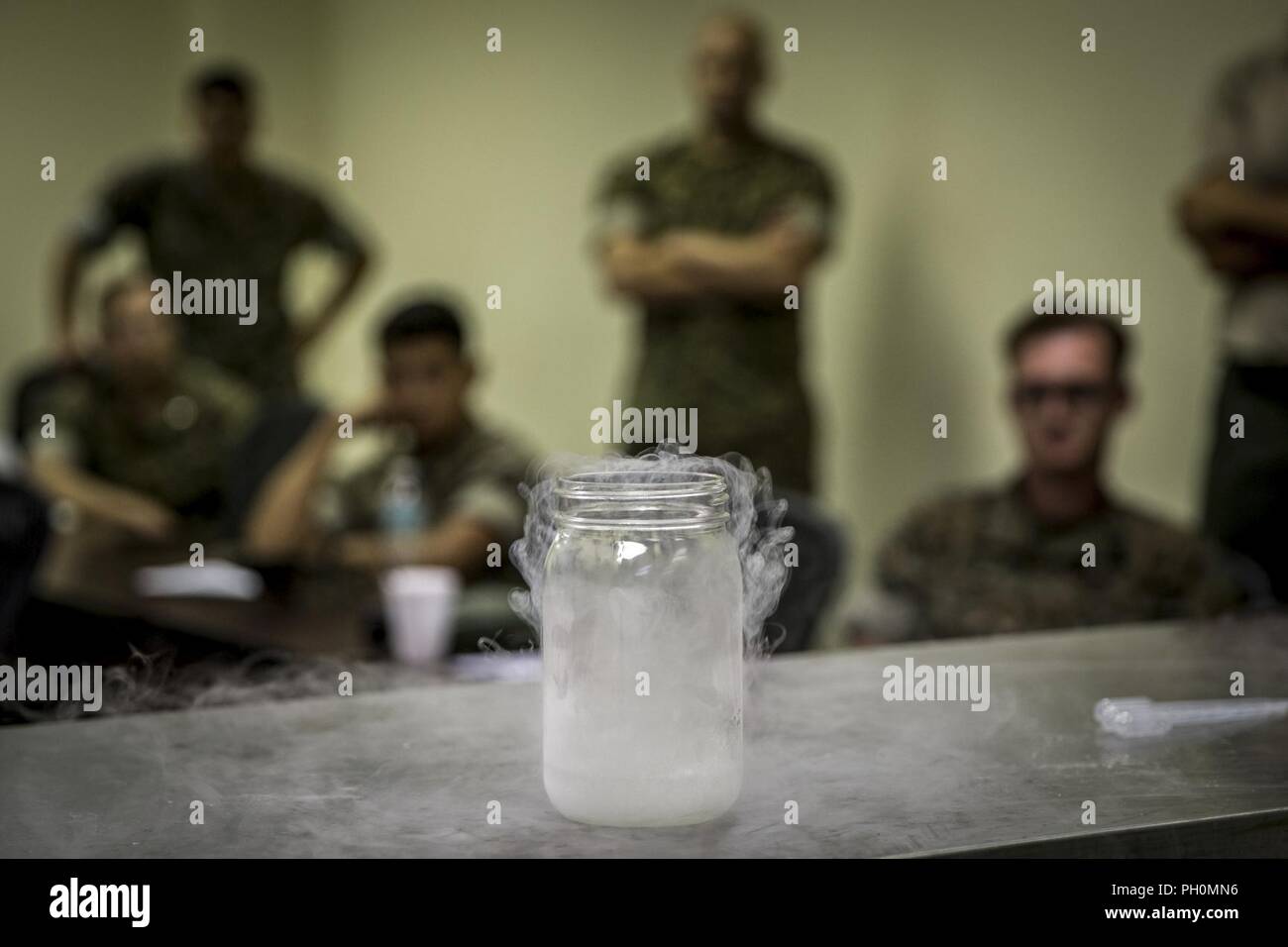 U.S. Marines with Chemical, Biological, Radiological, and Nuclear (CBRN) Platoon, Headquarters Battalion, 1st Marine Division, observe liquid nitrogen evaporte during the Concept of Real World CBRN Operations course at the Guardian Centers in Perry, Georgia, June 18, 2018. This training was conducted to enhance and refine the conduct of sensitive site exploitation, which supports the commander’s decision making cycle and maintains momentum during combat operations. Stock Photo