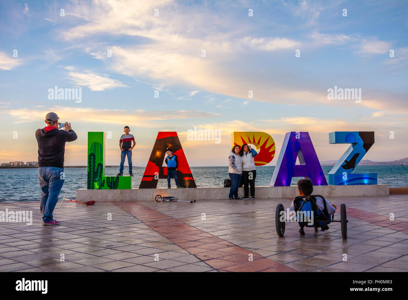 Visitors taking photos at the 'La Paz' Pueblos Magicos sign on the malecon in La Paz, Baja California Sur, Mexico. Stock Photo