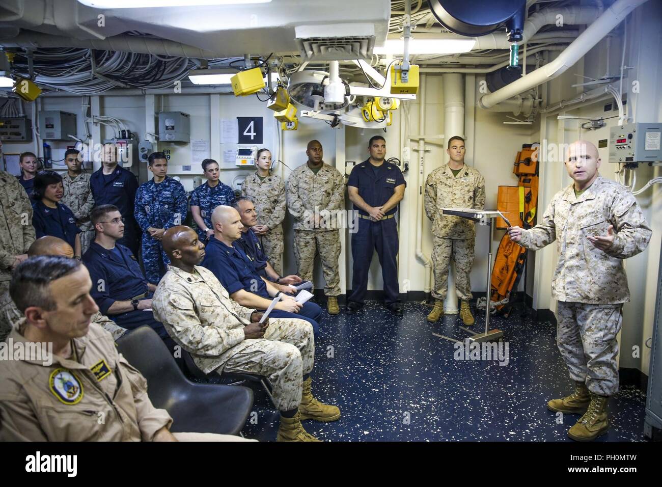 U.S. 5TH FLEET AREA OF OPERATIONS (June 17, 2018) U.S. Marine Corps Col. Farrell J. Sullivan, commanding officer of the 26th Marine Expeditionary Unit (MEU), speaks to Marines and Sailors during a ceremony celebrating the Navy Hospital Corps’ 120th birthday, aboard the Wasp-class amphibious assault ship USS Iwo Jima (LHD 7), June 17, 2018. The 26th MEU and Iwo Jima amphibious ready group are deployed to the U.S. 5th Fleet of operations in support of maritime security operations to reassure allies and partners and preserve the freedom of navigation and the free flow of commerce in the region. Stock Photo