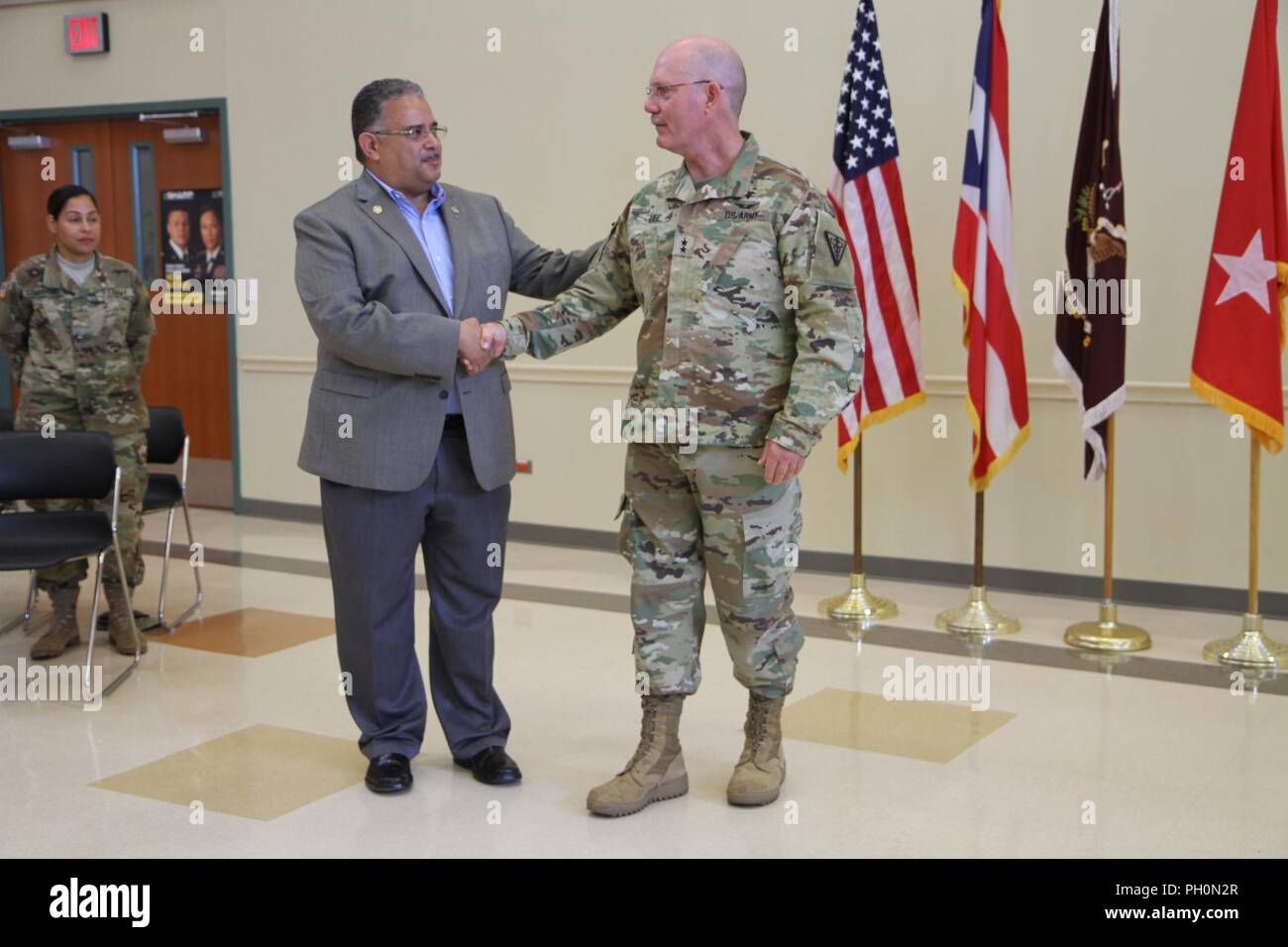 Maj. Gen. William Shane Lee, the Commander of the 3rd Medical Command (Deployment Support), gives the Secretary of Health for Puerto Rico, Dr. Rafael Rodriguez-Mercado, a division coin during the Humanitarian Service Medal Award ceremony. Stock Photo