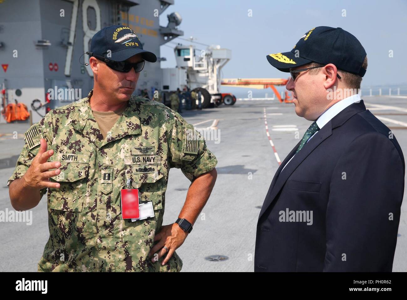 NORFOLK, Va. (June 20, 2018) – Matt Shipley, deputy assistant secretary of defense for force readiness, listens as Lt. Howard Smith, from Gainsville, Texas, assigned to USS Gerald R. Ford’s (CVN 78) air department, explains Ford’s unique flight deck layout during a tour of the ship. Stock Photo