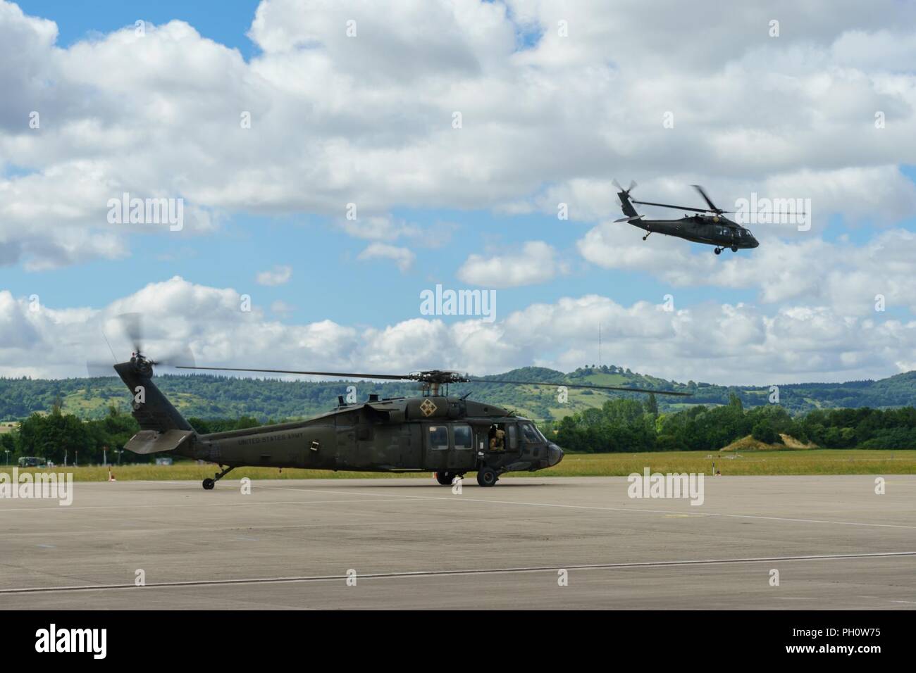 U.S. Army UH-60 Blackhawk helicopter flight crews with the 4th Combat Aviation Brigade, 4th Infantry Division, out of Fort Carson, Colorado, land at the Illesheim Army Airfield in Germany, June 22, 2018. Soldiers of the brigade arrived in Germany to begin a nine-month deployment in support of Atlantic Resolve, a U.S. endeavor to fulfill NATO commitments by rotating U.S.-based units throughout the European theater to deter aggression against NATO allies and partners in Europe. Stock Photo