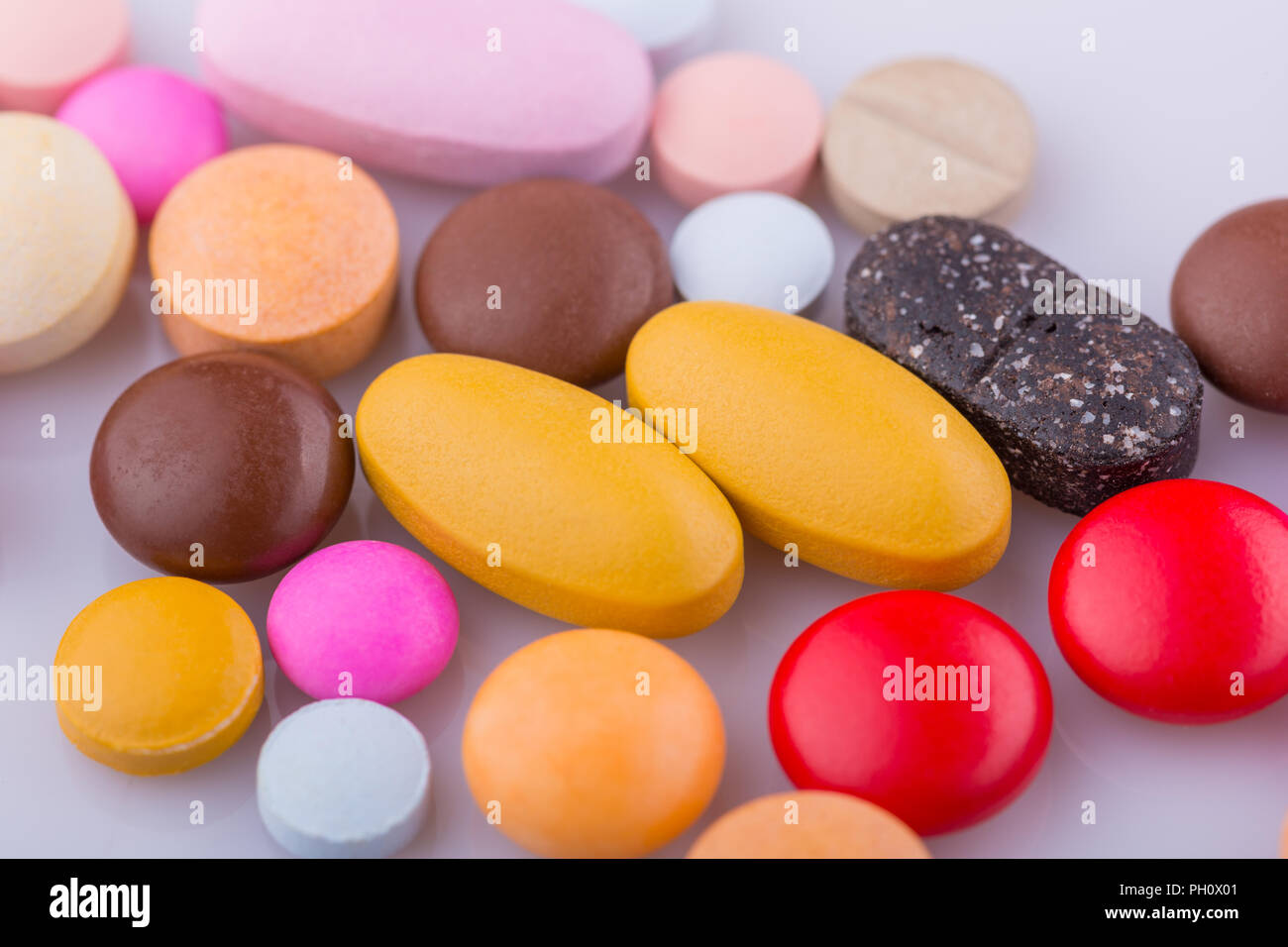 Tablets pills capsule heap mix therapy drugs, over a white background