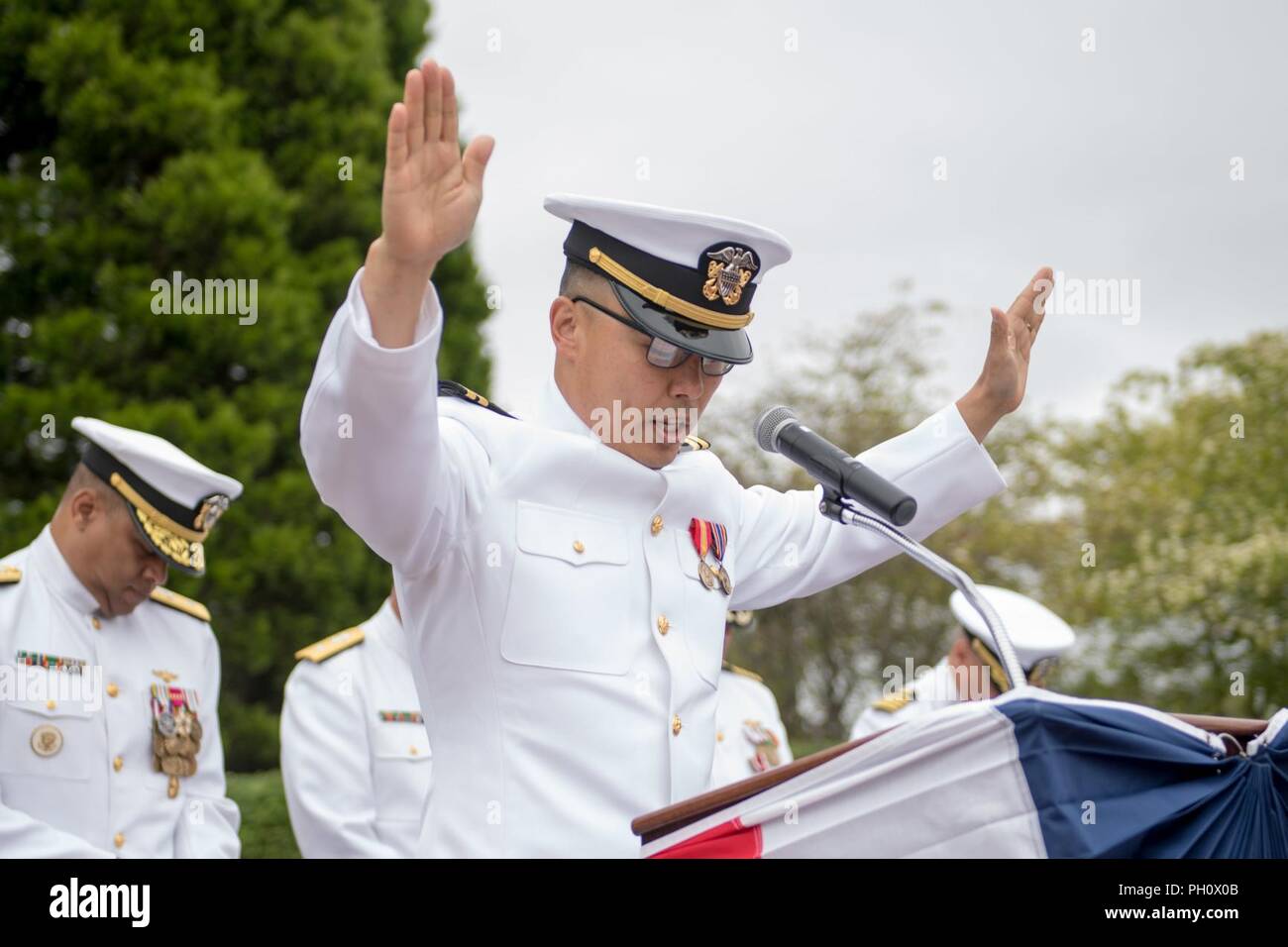 Everett, Wash. (June 22, 2018) Lt. Richard Min, Naval Station Everett's command chaplain, gives the benediction during a change of command ceremony for Naval Station Everett (NSE). During the ceremony Capt. Mike Davis relieved Capt. Mark Lakamp as commanding officer of NSE. Stock Photo
