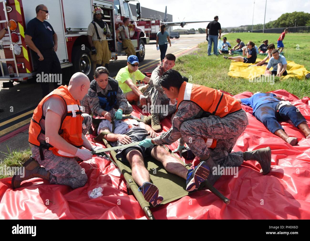 Members of the 81st Medical Group provide triage to “victims” during a major accident response exercise on the flight line at Keesler Air Force Base, Mississippi, June 21, 2018. The exercise scenario simulated a C-130J Super Hercules in-flight emergency causing a plane crash which resulted in a mass casualty response event. This exercise tested the base’s ability to respond in a crisis situation. Stock Photo