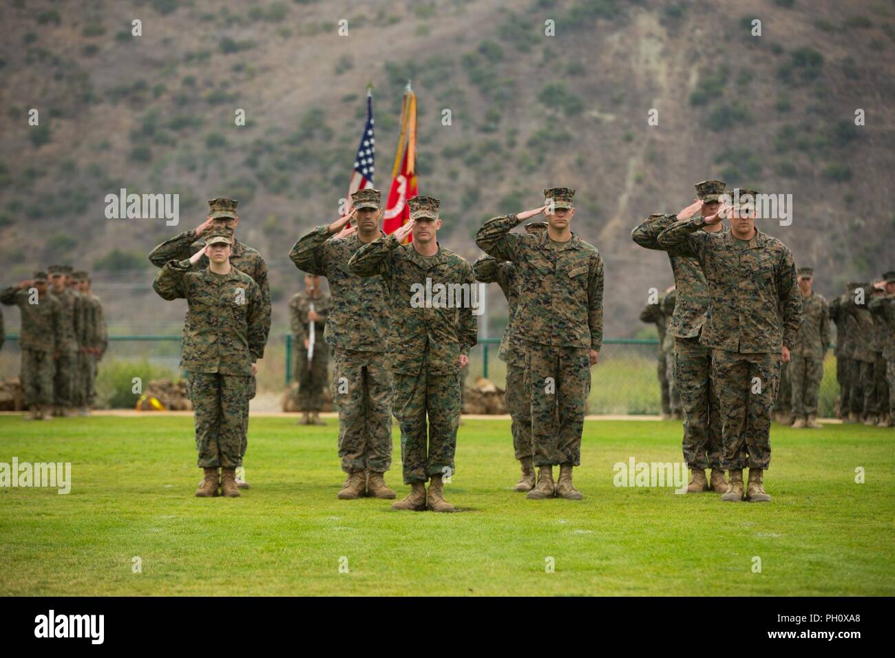 U.S. Marines with 1st Combat Engineer Battalion (CEB), 1st Marine Division, salute during a change of command ceremony at Marine Corps Base Camp Pendleton, Calif., June 22, 2018. The ceremony was held as a formal transfer of authority and responsibility from Lt. Col. Christopher M. Haar, offgoing commanding officer of 1st CEB, to Lt. Col. Michelle I. Macander, incoming commanding officer of 1st CEB. Stock Photo