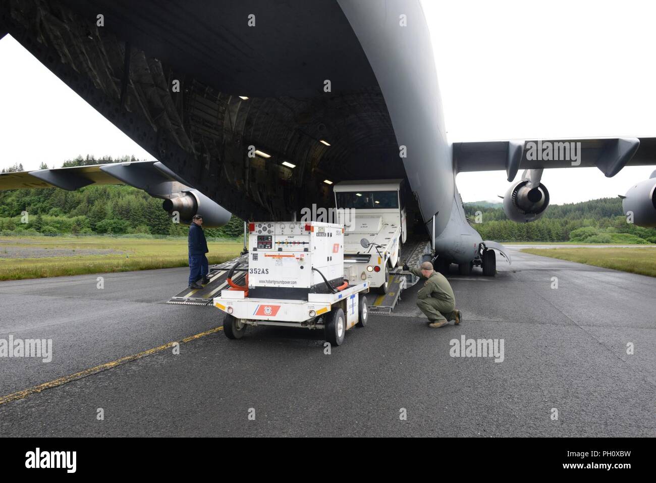 Coast Guardsmen from Air Station Kodiak and airmen with the Alaska Air National Guard 249th Airlift Squadron load a C-17 Globemaster III with Coast Guard equipment in Kodiak, Alaska, June 21, 2018. The equipment was delivered to Coast Guard Forward Operating Location Kotzebue, which opens July 1, 2018, in support of Arctic Shield 2018. U.S. Coast Guard Stock Photo