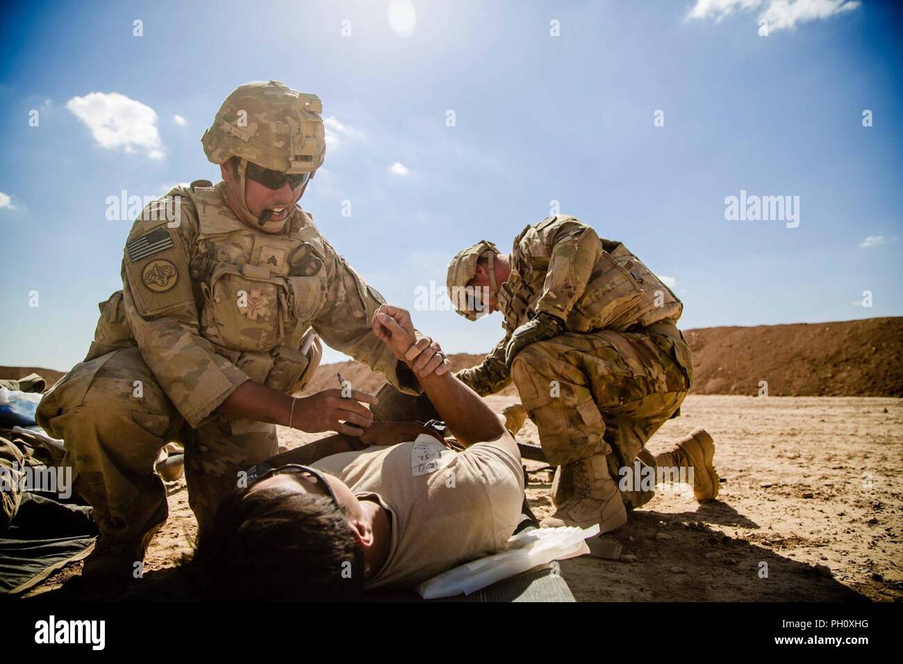 U.S. Army Sgt. Joshua Padilla, 3rd Cavalry Regiment, writes vital information on a simulated casualty during a mass casualty exercise near the Iraqi-Syrian border, June 20, 2018. Iraqi Security Forces and Coalition partners provided fire support and continually work on combat skills to assist the Syrian Democratic Forces as they continued Operation Roundup, the military offensive to rid the final pockets of the terrorist organization from the Middle Euphrates River Valley in Syria. Stock Photo