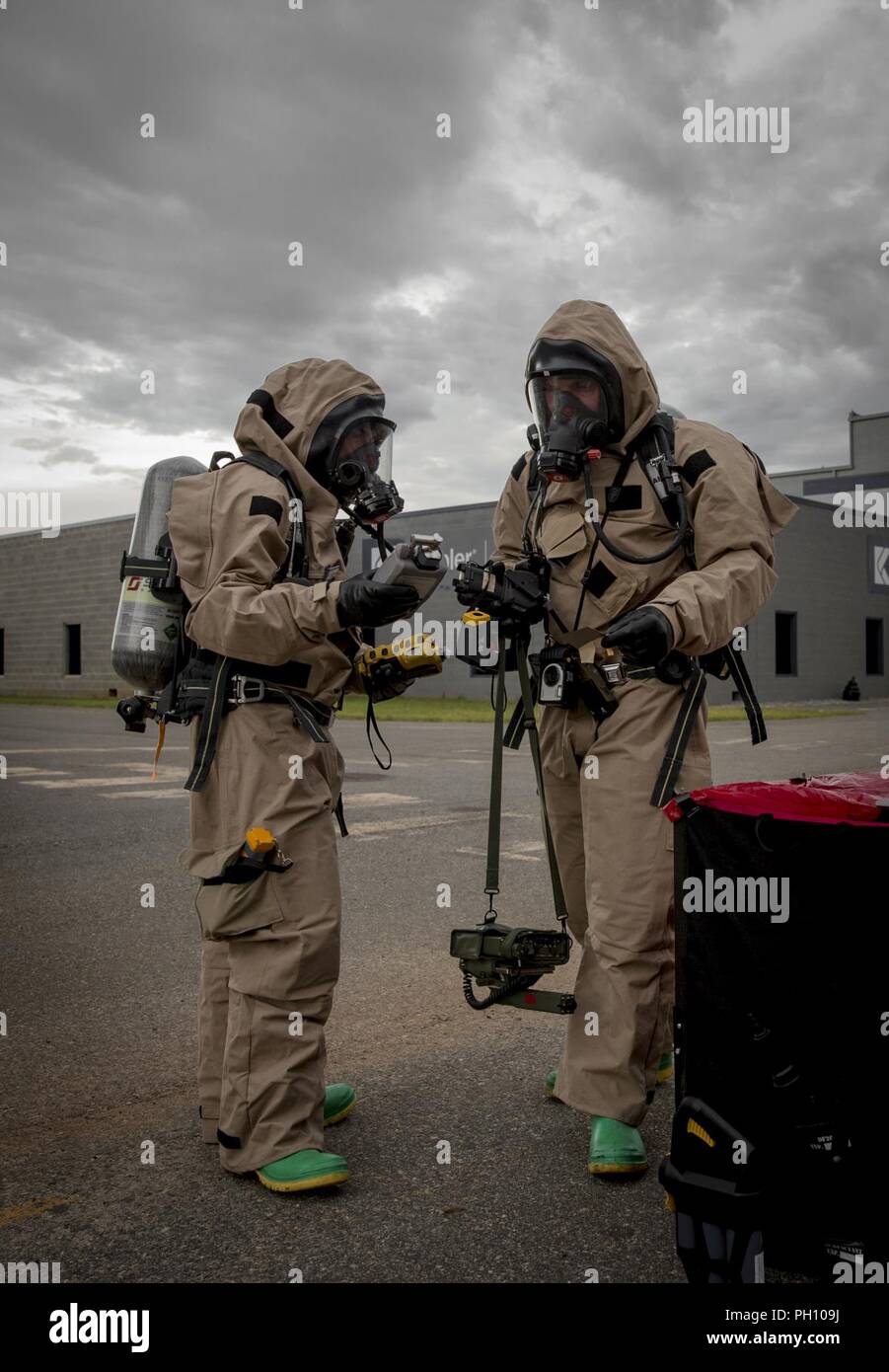 U.S. Marines with Chemical, Biological, Radiological, and Nuclear (CBRN) Platoon, Headquarters Battalion, 1st Marine Division, adjust their hazerdous material suits during the Concept of Real World CBRN Operations course at the Guardian Centers in Perry, Georgia, June 21, 2018. This training was conducted to enhance and refine the conduct of sensitive site exploitation, which supports the commander’s decision making cycle and maintains momentum during combat operations. Stock Photo
