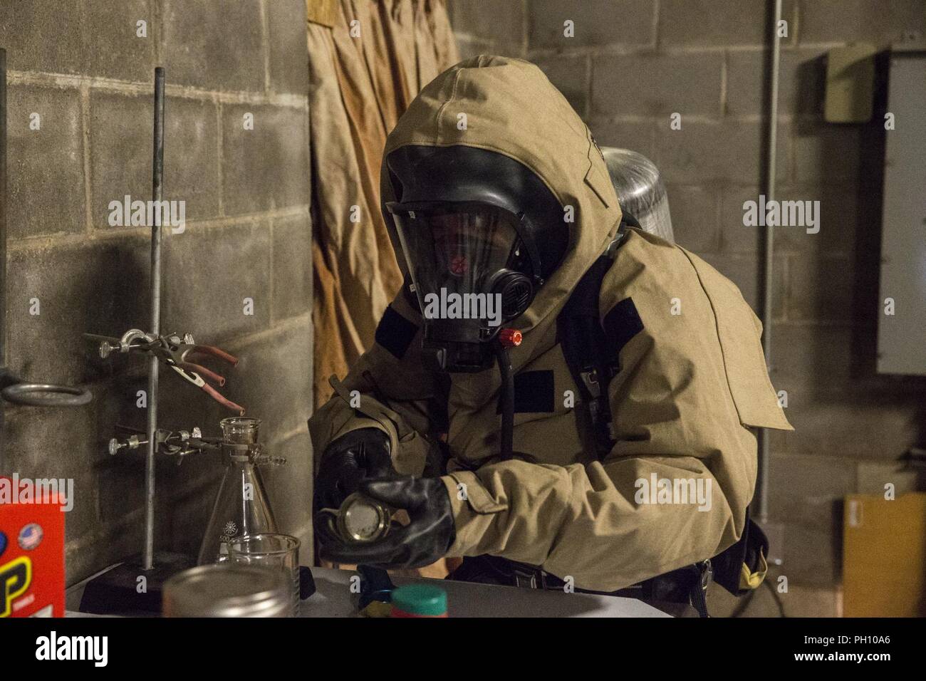 A U.S. Marine with Chemical, Biological, Radiological, and Nuclear (CBRN) Platoon, Headquarters Battalion, 1st Marine Division, collects a sample during the Concept of Real World CBRN Operations course at the Guardian Centers in Perry, Georgia, June 22, 2018. This training was conducted to enhance and refine the conduct of sensitive site exploitation, which supports the commander’s decision making cycle and maintains momentum during combat operations. Stock Photo