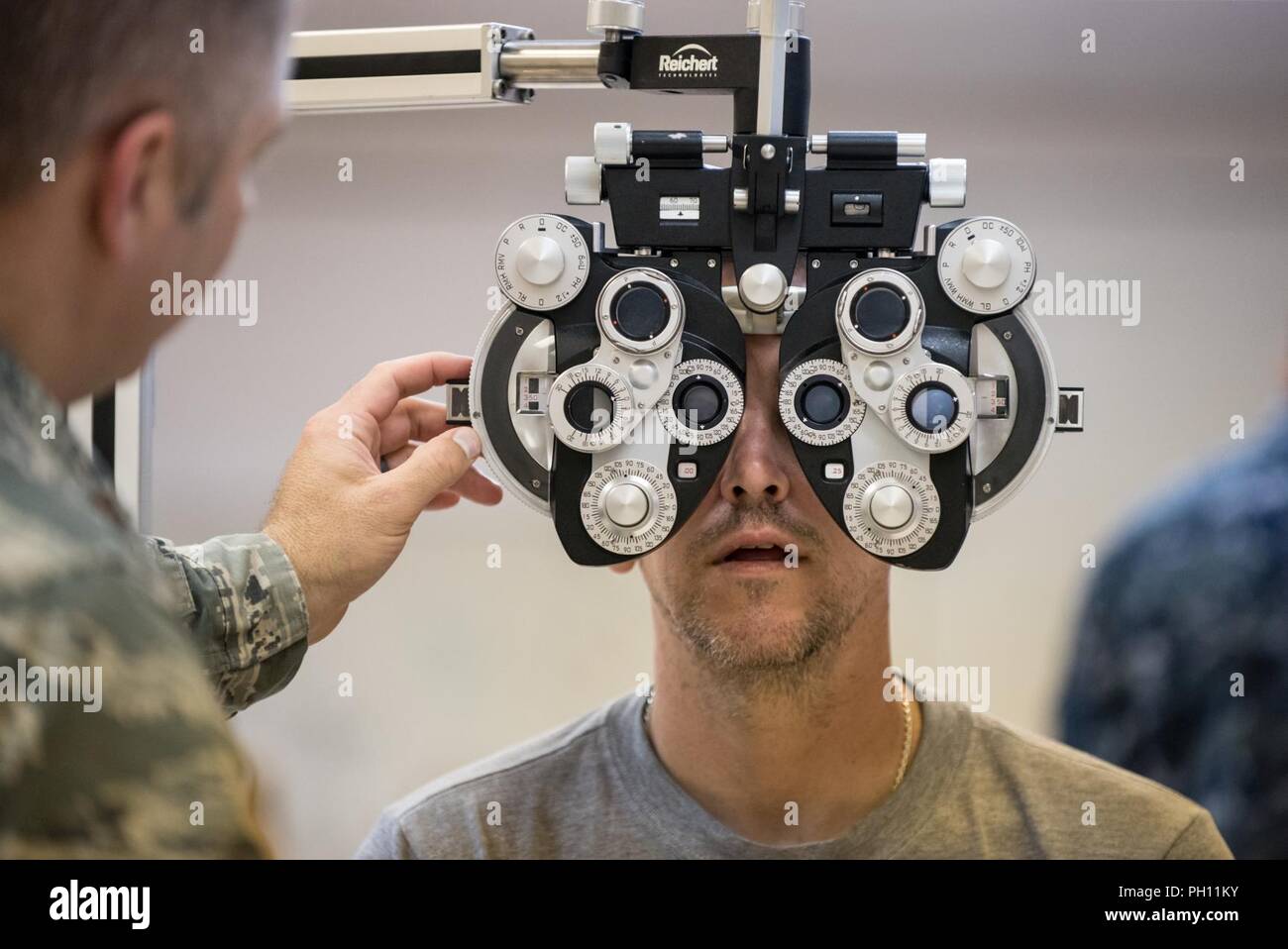 U.S. Air Force Maj. Brett Ringger, an optometrist from the Texas Air National Guard’s 136th Airlift Wing, tests a patient’s vision at a health-care clinic being operated by the Air National Guard and U.S. Navy Reserve at Lee County High School in Beattyville, Ky., June 23, 2018. The clinic is one of four that comprised Operation Bobcat, a 10-day mission to provide military medical troops with crucial training in field operations and logistics while offering no-cost health care to the residents of Eastern Kentucky. The clinics, which operated from June 15-24, offered non-emergent medical care;  Stock Photo