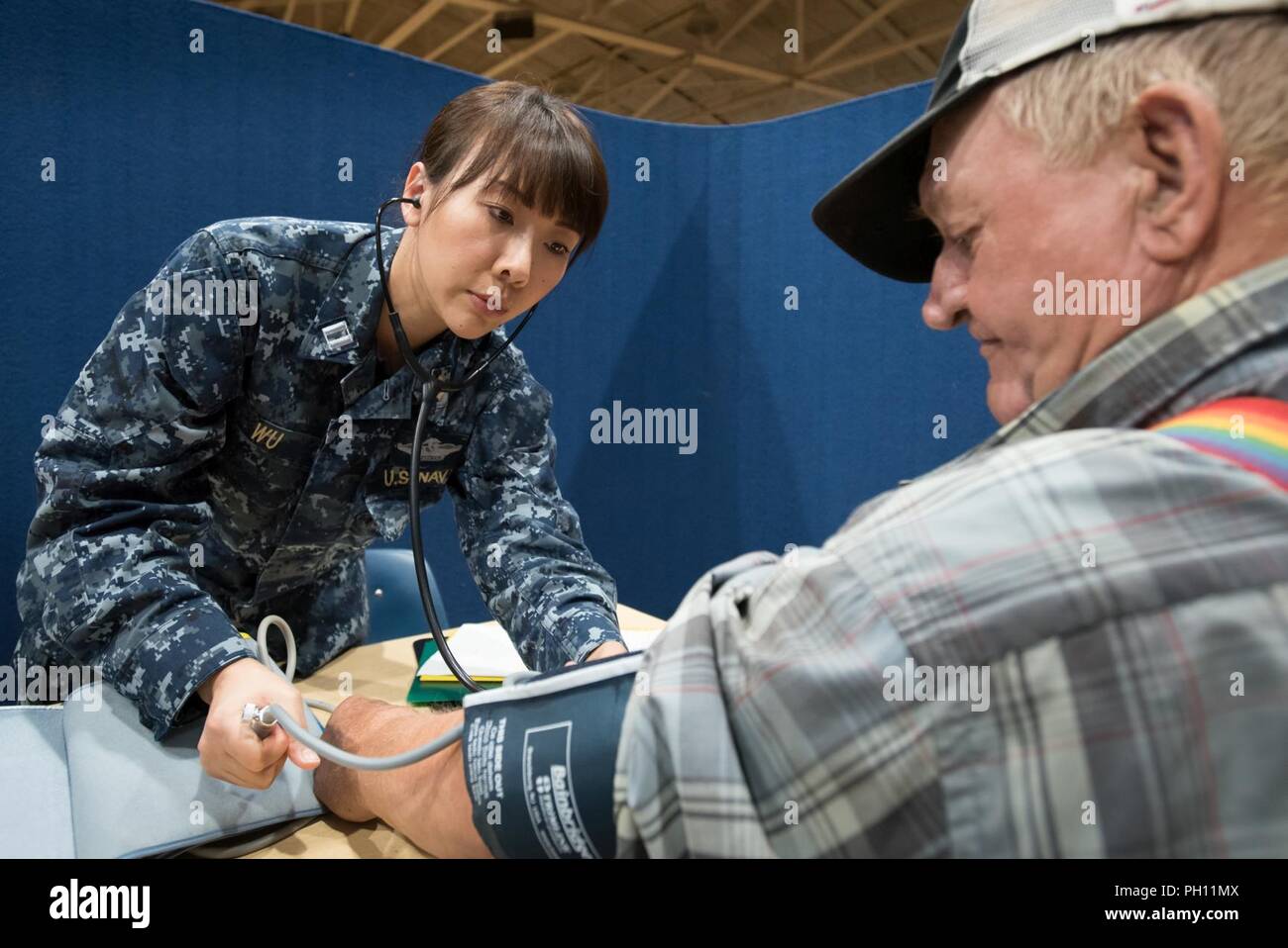 U.S. Navy Lt. Xin Wu, a nurse from Expeditionary Medical Facility Bethesda in Maryland, takes the blood pressure of a patient at a health-care clinic being operated by the Air Guard and U.S. Navy Reserve at Lee County High School in Beattyville, Ky., June 21, 2018. The clinic is one of four that comprised Operation Bobcat, a 10-day mission to provide military medical troops with crucial training in field operations and logistics while offering no-cost health care to the residents of Eastern Kentucky. The clinics, which operated from June 15-24, offered non-emergent medical care; sports physica Stock Photo