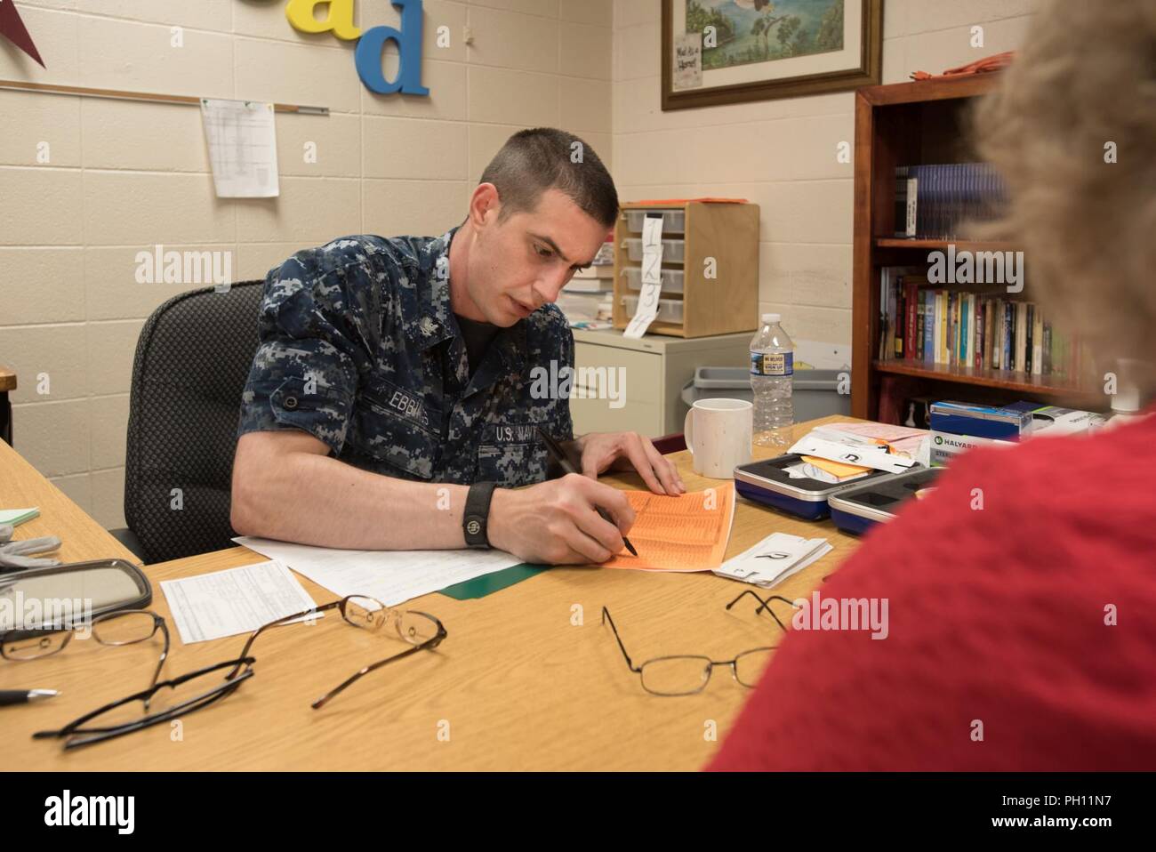 U.S. Navy HM3 Troy Ebbings, a corpsman from Expeditionary Medical Facility Great Lakes in Illinois, fills out an order for eyeglasses at a health-care clinic at Owsley County High School in Booneville, Ky., June 24, 2018. The clinic is one of four that comprised Operation Bobcat, a 10-day mission to provide military medical troops with crucial training in field operations and logistics while offering no-cost health care to the residents of Eastern Kentucky. The clinics, which operated from June 15-24, offered non-emergent medical care; sports physicals; dental cleanings, fillings and extractio Stock Photo