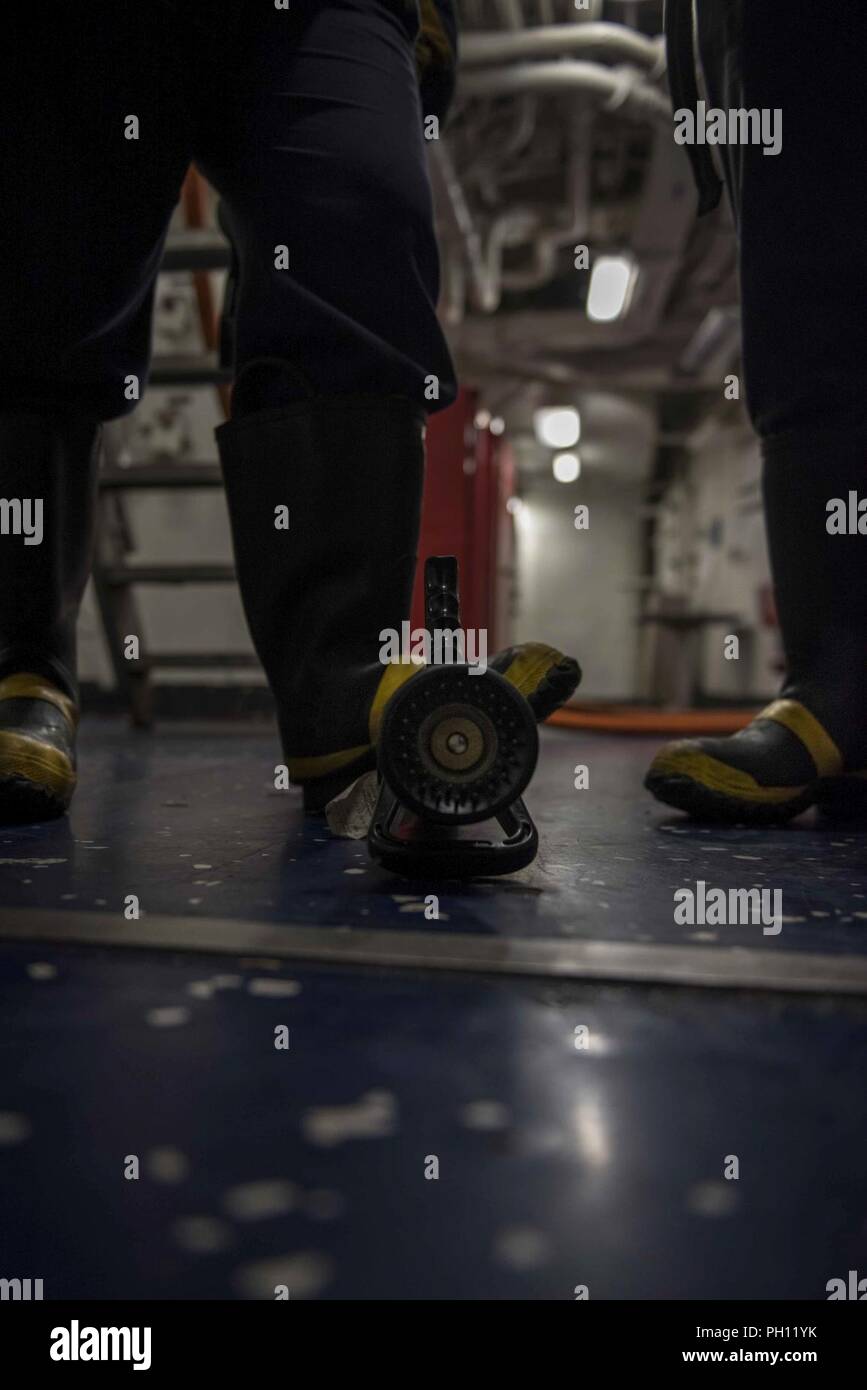 ATLANTIC OCEAN (June 23, 2018) Members of the damage control training team secure a fire hose during a training exercise aboard the aircraft carrier USS George H.W. Bush (CVN 77). The ship is underway conducting routine training exercises to maintain carrier readiness. Stock Photo