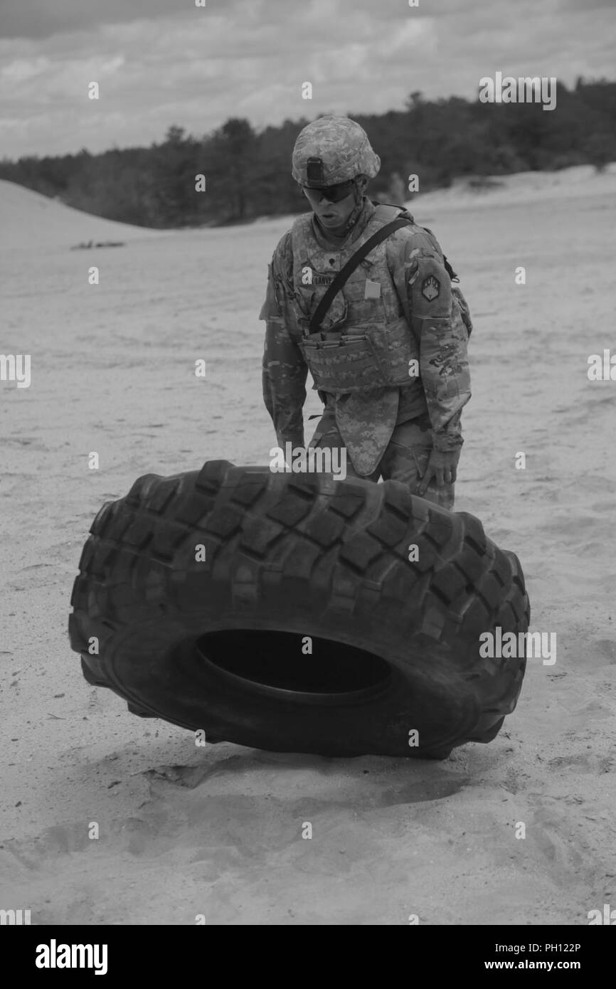 U.S. Army Spc. Andre Van Lange, assigned to 48th Chemical Brigade, does a tire flip during the stress shoot portion of the Best Warrior Competition, Fort Dix, New Jersey, June 19, 2018.The 20th Chemical, Biological, Radiological, Nuclear, Explosive Best Warrior Competition is a division level contest that identifies one Soldier and one Non-commissioned Officer to proceed to FORSCOM's Best Warrior Competition.( U.S. Army Stock Photo