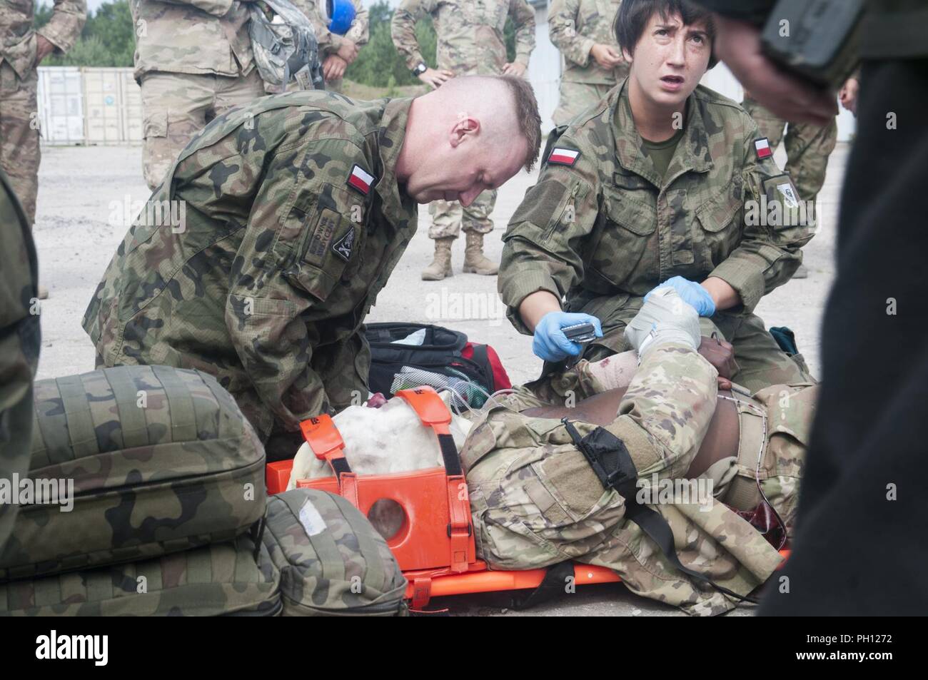 A U.S. Army Soldier assigned to 962nd Ordnance Company, 143rd Sustainment Support Battalion, receives medical aid from 10th Armoured Cavalry Brigade Soldiers during a first-responder training exercise in Swieteszow, Poland, June 20, 2018. The 962nd Ordnance, a U.S. Army Reserve unit from New York, is deployed in support of Atlantic Resolve in Europe. Stock Photo