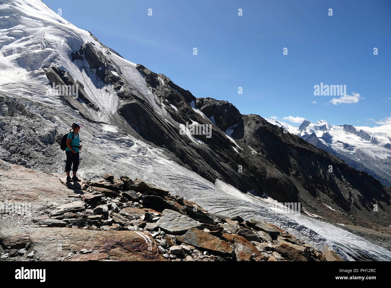 Solitatry walker and Weissmies mountain from Hohsaas cable car above Saas Grund, Switzerland Stock Photo