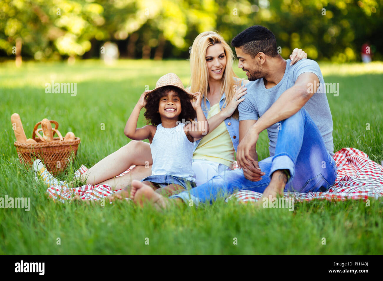 Picture of lovely couple with their daughter having picnic Stock Photo