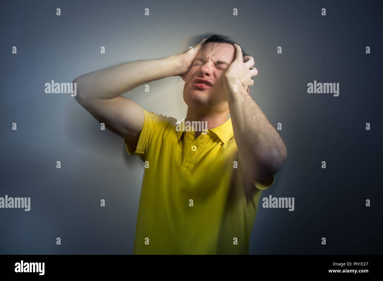Young man suffering from an intense headache/migraine/anxiety attack - color toned image Stock Photo