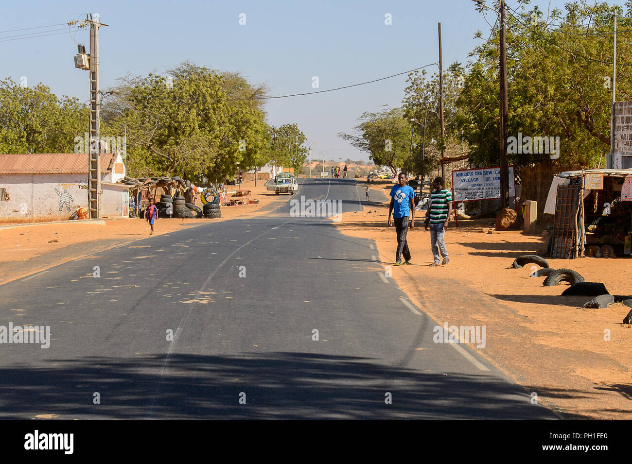 LAMPOUL DESERT village, SENEGAL - APR 23, 2017: Unidentified Senegalese two men stand beside the road in a village near the Lampoul Desert Stock Photo