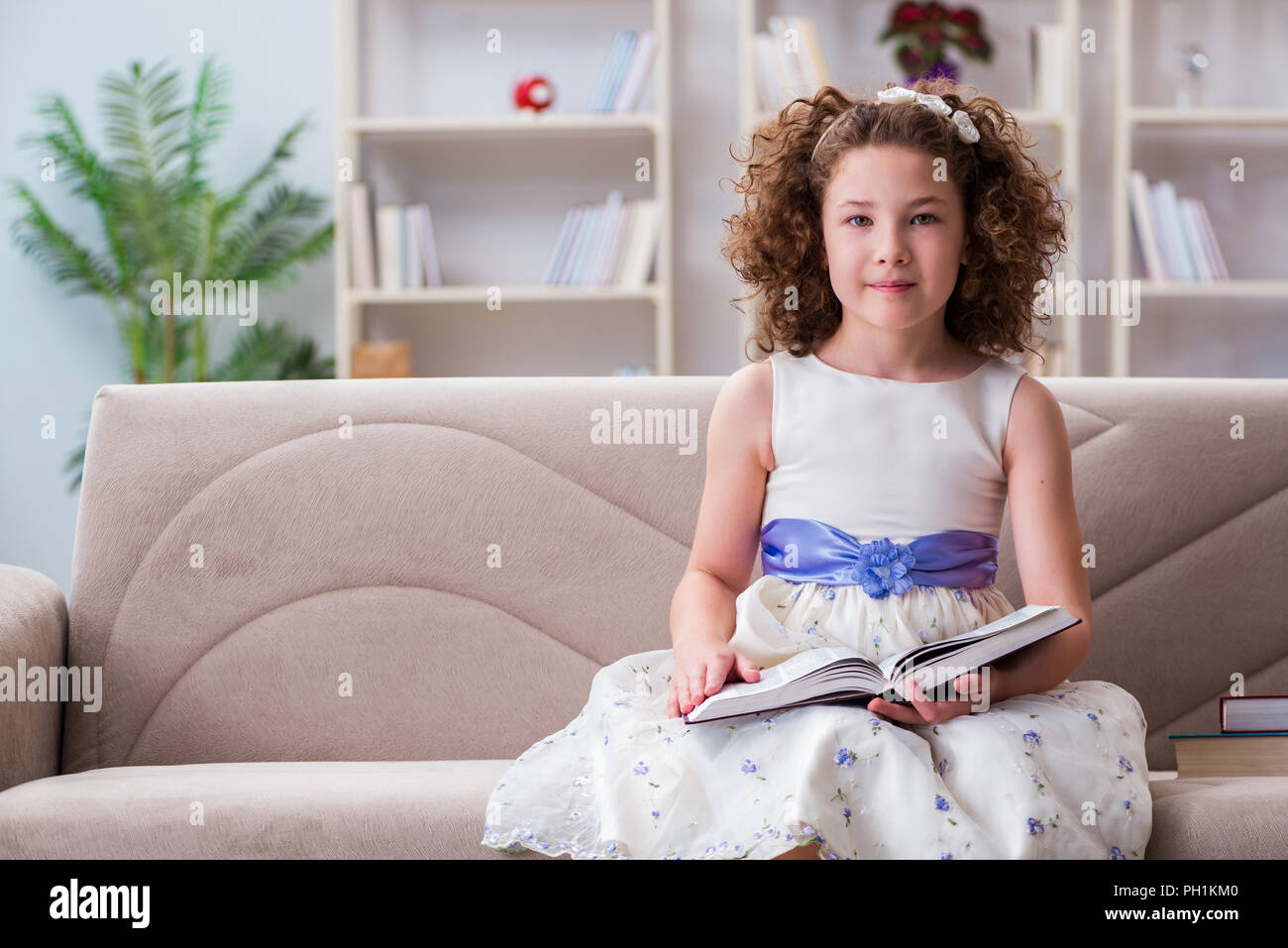 Small girl reading books at home Stock Photo - Alamy