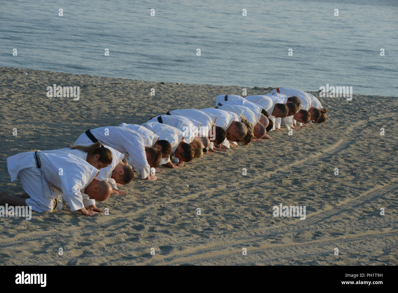 group of shotokan karatekas doing the welcome ritual at the beach in ...