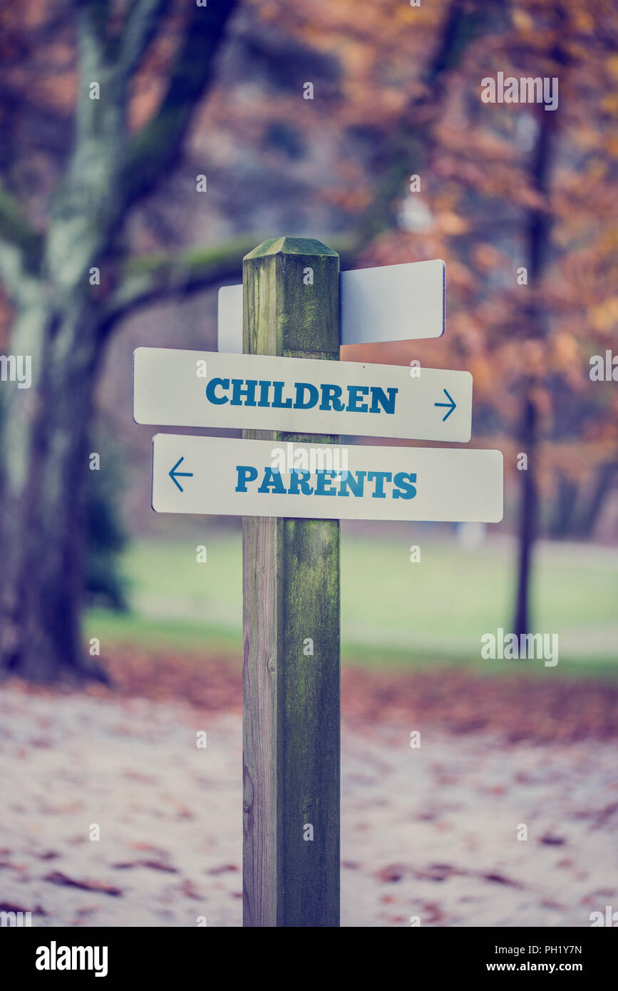 Signpost in a park or forested area with arrows pointing two opposite ...