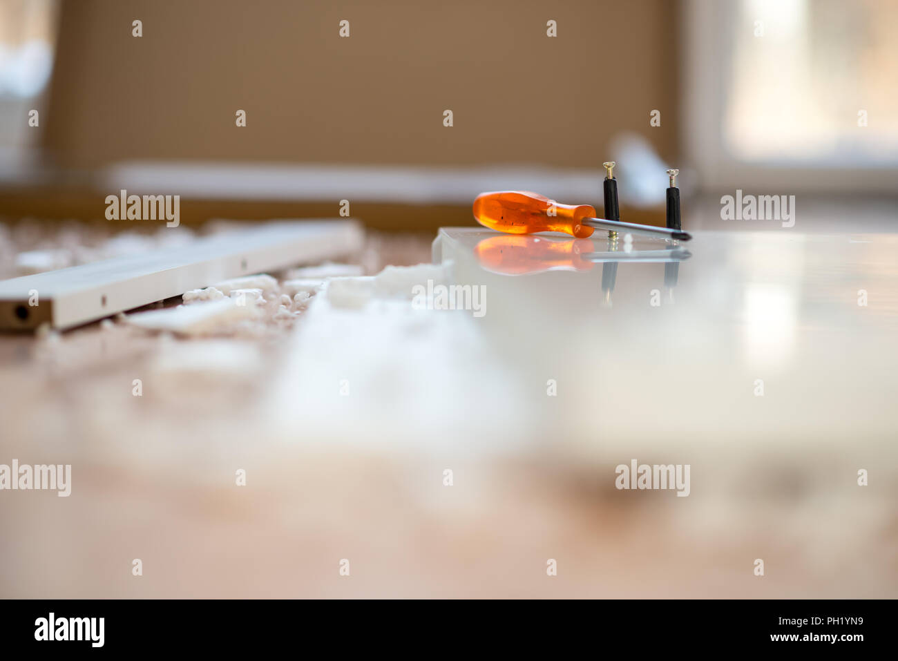 Screwdriver Lying On A Work Bench With Plaugs Used To Assemble