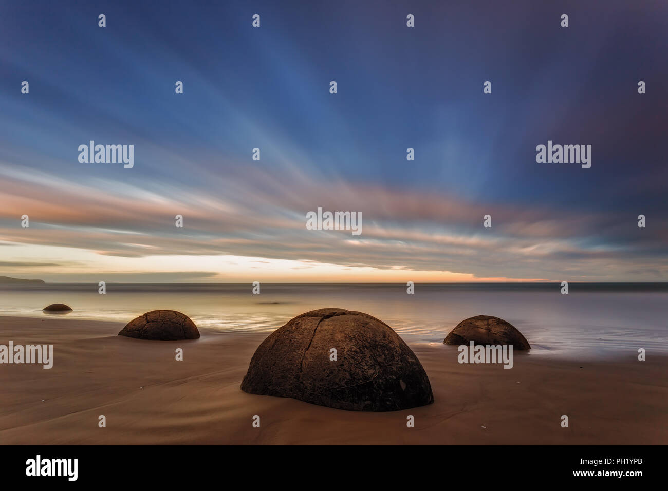 The Moeraki Boulders are round stone balls and an absolute tourist ...