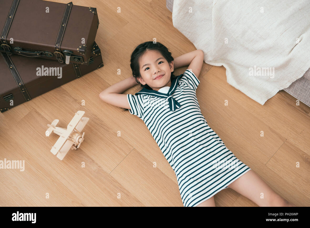 kid lying on her back and looking up in the room. She seems very