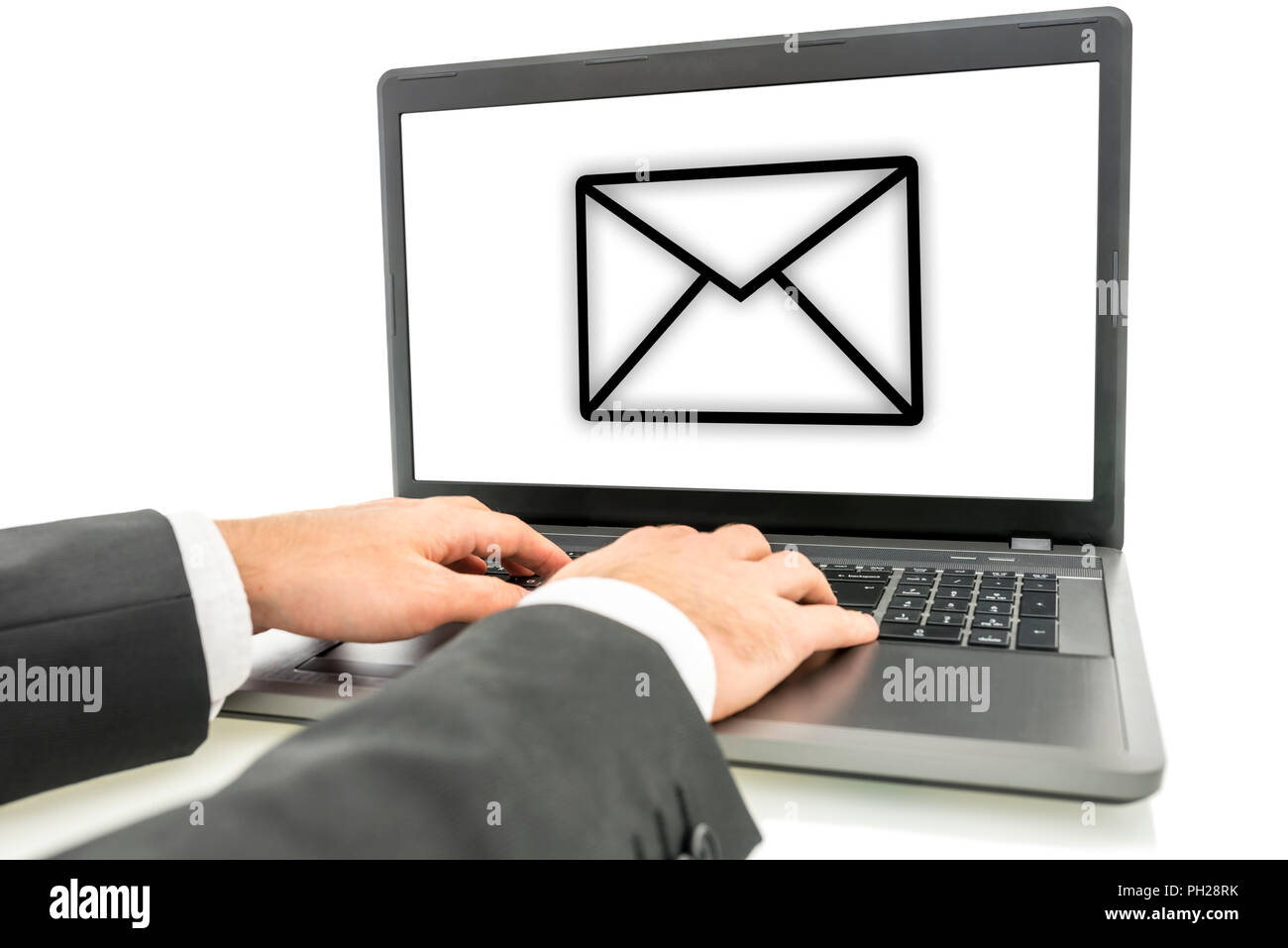 Businessman sending email correspondence online on his laptop computer with the envelope icon visible on his screen Stock Photo