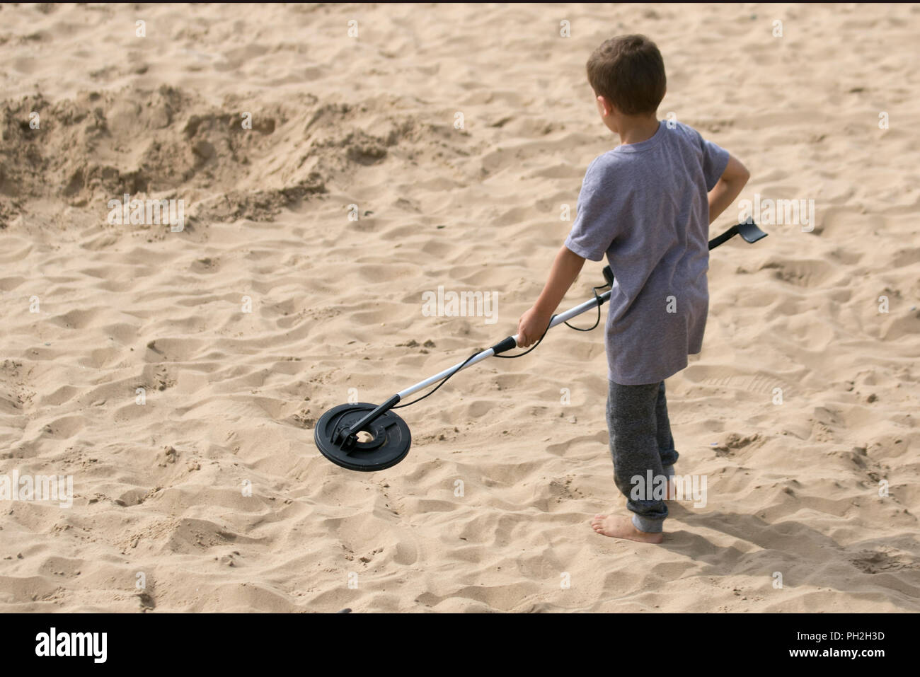 Boy using junior metal detector at Lytham Saint Anne's, Lancashire. UK  Weather 30/08/2018. Young boy a Metal dectorists scours the beach looking  for treasure, equipment, discovery, history, sensor, adventure, electrical,  searching, detect,