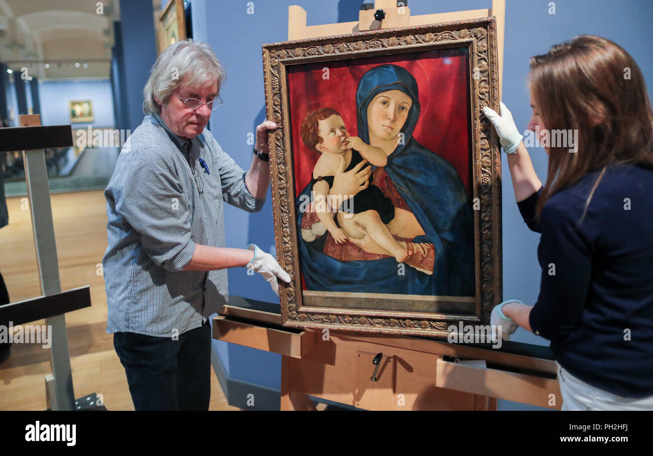 30.08.2018, Berlin: Collection administrator Peter Scheel and restorer Maria Zielke lift the painting 'Maria mit Kind' by Giovanni Bellini in the collection of paintings of the National Museums in Berlin onto an easel. The pictures are being prepared for transport to an exhibition in London. An exhibition shown in Berlin and London is dedicated to the work of the two Renaissance artists Giovanni Bellini (c. 1435-1516) and Andrea Mantegna (c. 1431-1506). For the show, the National Museums in Berlin and the National Gallery in London are cooperating with the British Museum. Photo: Jens Büttner/d Stock Photo