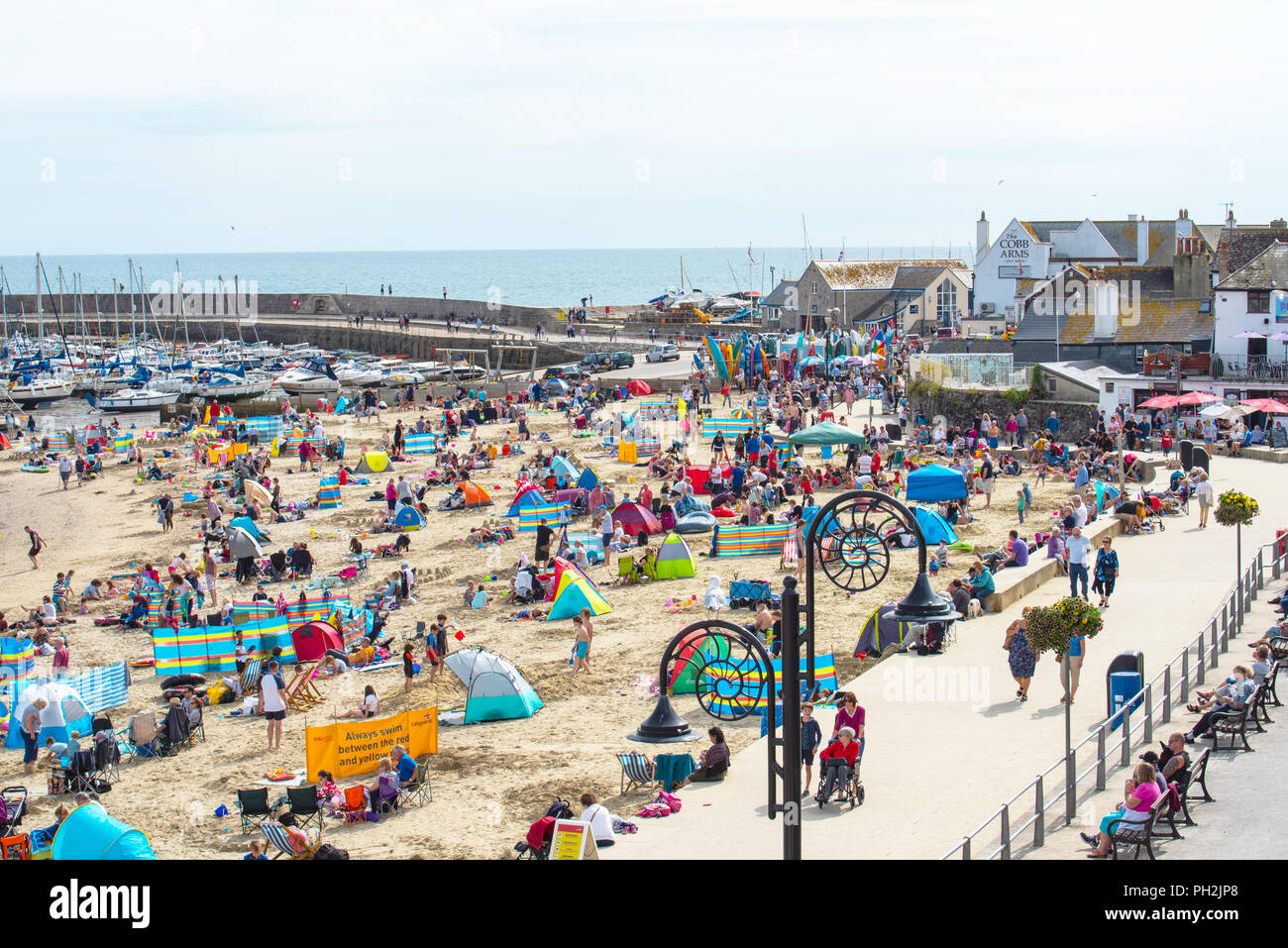 Lyme Regis, Dorset, UK. 30th August 2018.  UK Weather:  The picturesque beach at the seaside resort of Lyme Regis was crowded again as holidaymakers enjoyed the return of the sunshine.  The bright and sunny conditions are set to continue into the weekend.  Credit: Celia McMahon/17�Թ����� Live News Stock Photo