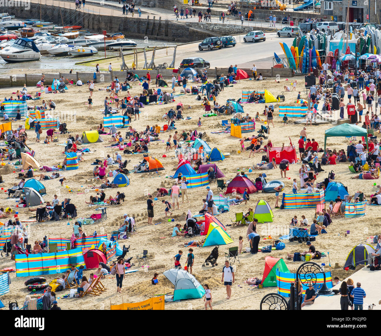 Lyme Regis, Dorset, UK. 30th August 2018.  UK Weather:  The picturesque beach at the seaside resort of Lyme Regis was crowded again as holidaymakers enjoyed the return of the sunshine.  The bright and sunny conditions are set to continue into the weekend.  Credit: Celia McMahon/17�Թ����� Live News Stock Photo