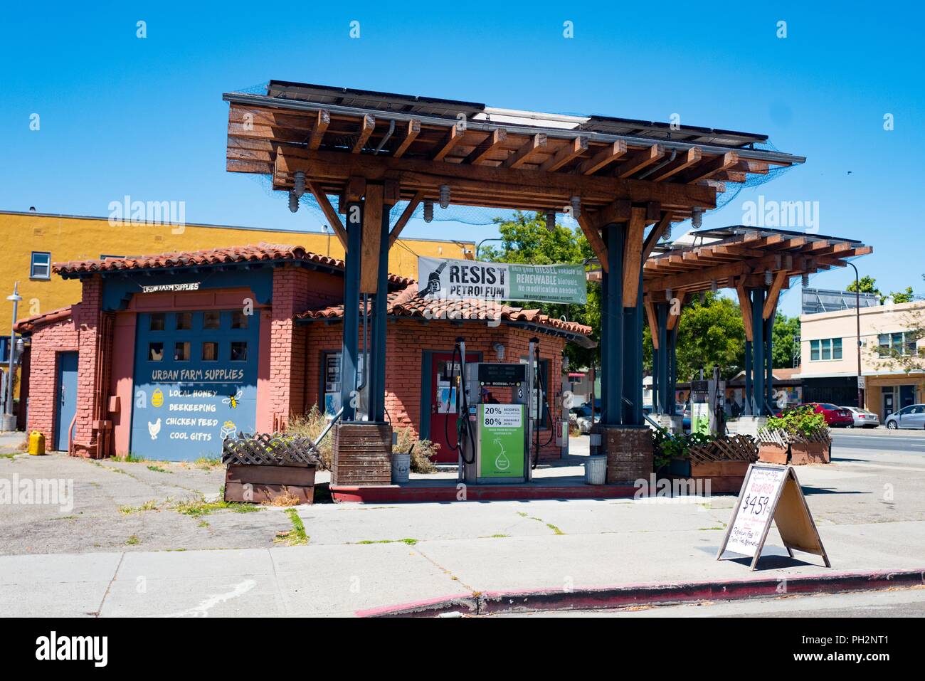 Facade of BiofuelOasis, a worker-owned cooperative gas station and supply store in downtown Berkeley, California, with gas pump providing locally-made biodiesel fuel and sign reading Resist Petroleum, June 12, 2018. () Stock Photo