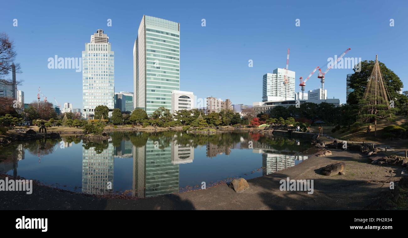 Metropolitan area skyscrapers reflections in water of a pond at the Kyu Shiba Rikyu Garden, Minato, Tokyo, Japan, December 7, 2017. () Stock Photo