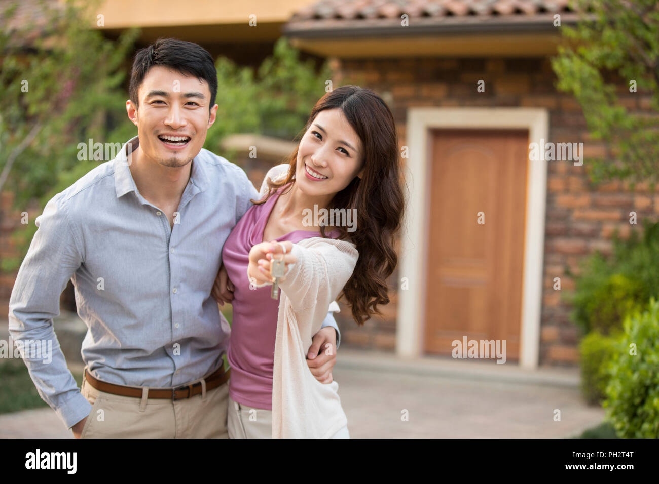 Happy young couple holding keys to new house Stock Photo - Alamy