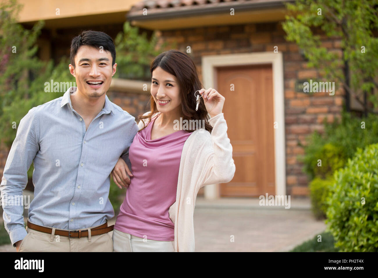 Happy young couple holding keys to new house Stock Photo - Alamy