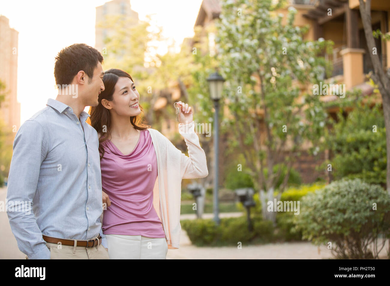 Happy young couple holding keys to new house Stock Photo - Alamy
