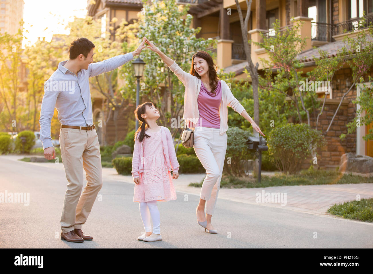 Happy young family playing in front of their new house Stock Photo - Alamy