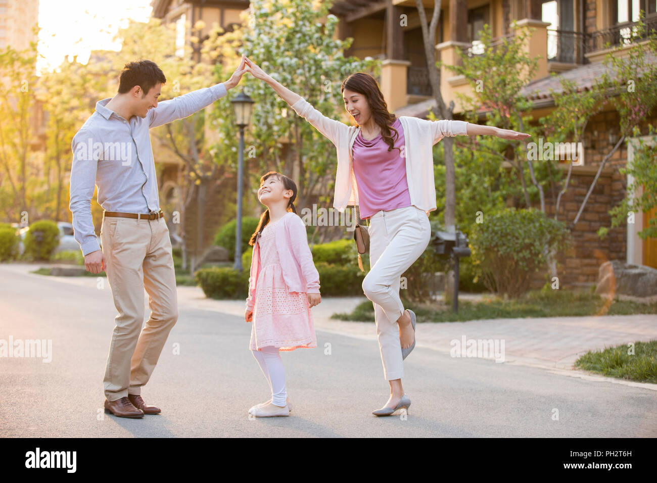 Happy young family playing in front of their new house Stock Photo - Alamy