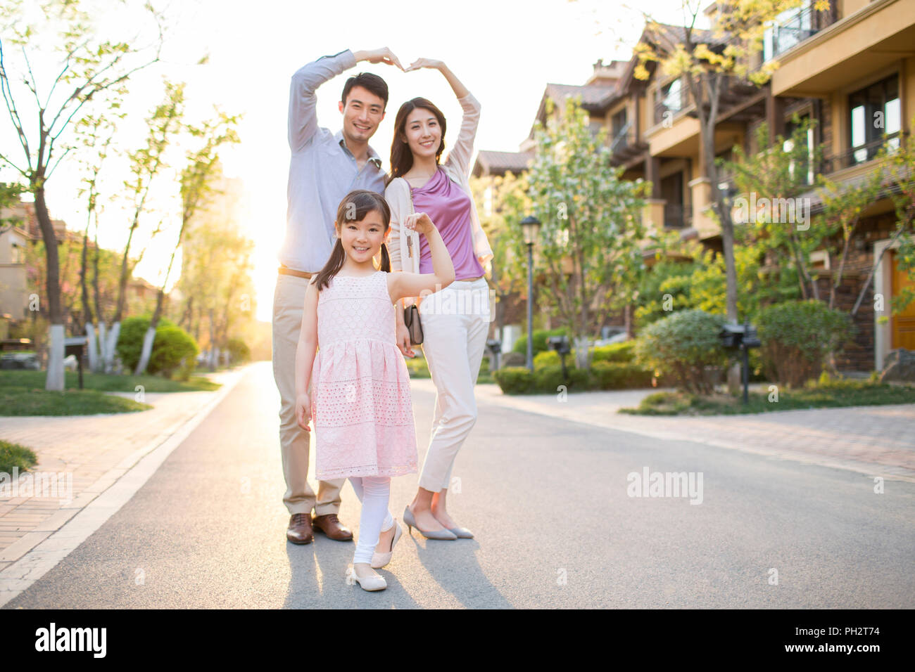 Happy young family holding keys to new house Stock Photo - Alamy